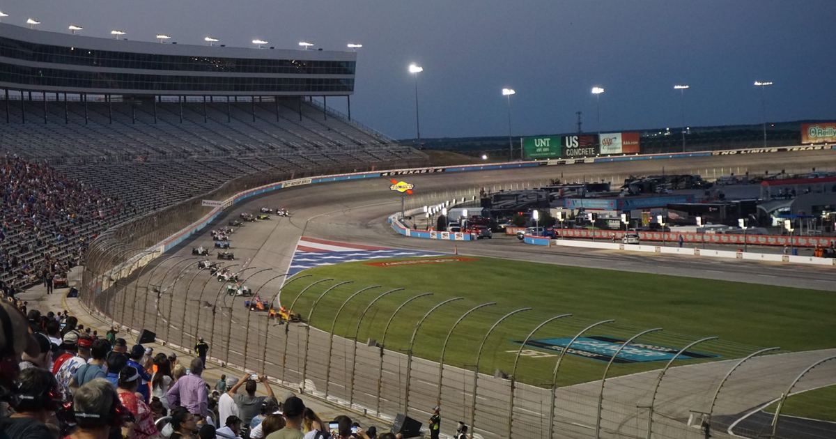 an IndyCar accelerating hard out of a corner on a road course, the moment push-to-pass would typically be deployed