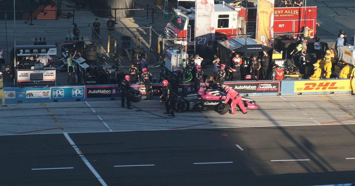 Kyle Kirkwood's Andretti Global car (#27) during a pit stop, with a banner bearing his name visible in the background