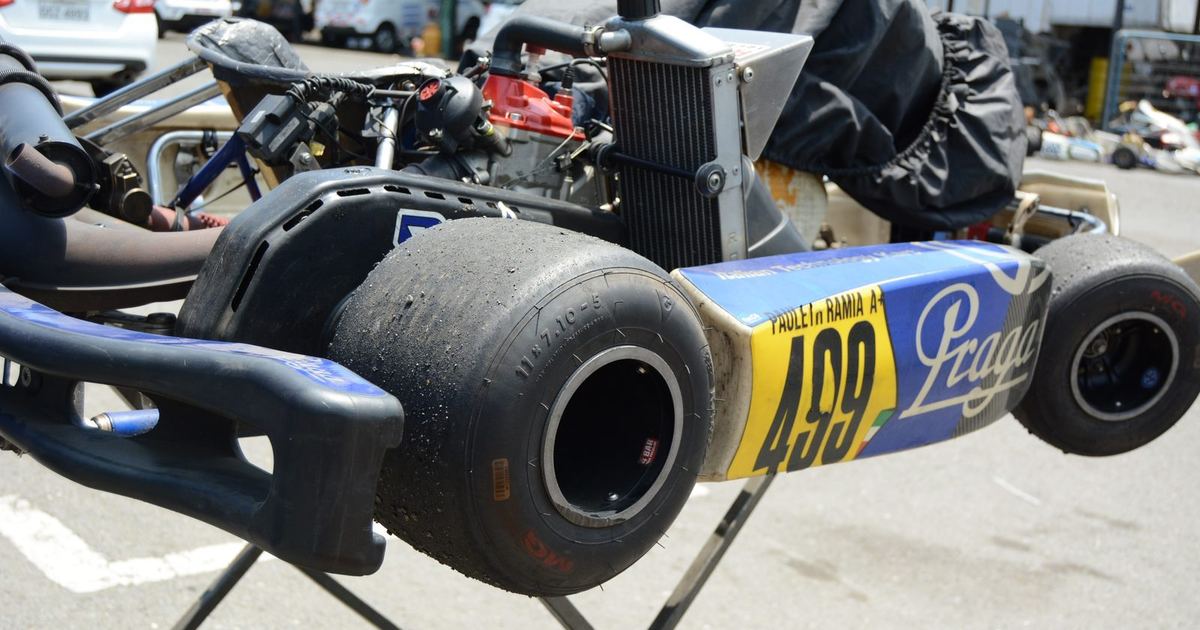 a young driver in a competitive kart, positioned to suggest a comparison with sim racing training