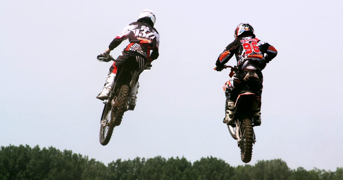 a supercross rider clearing a jump combination, illustrating rhythm-section riding