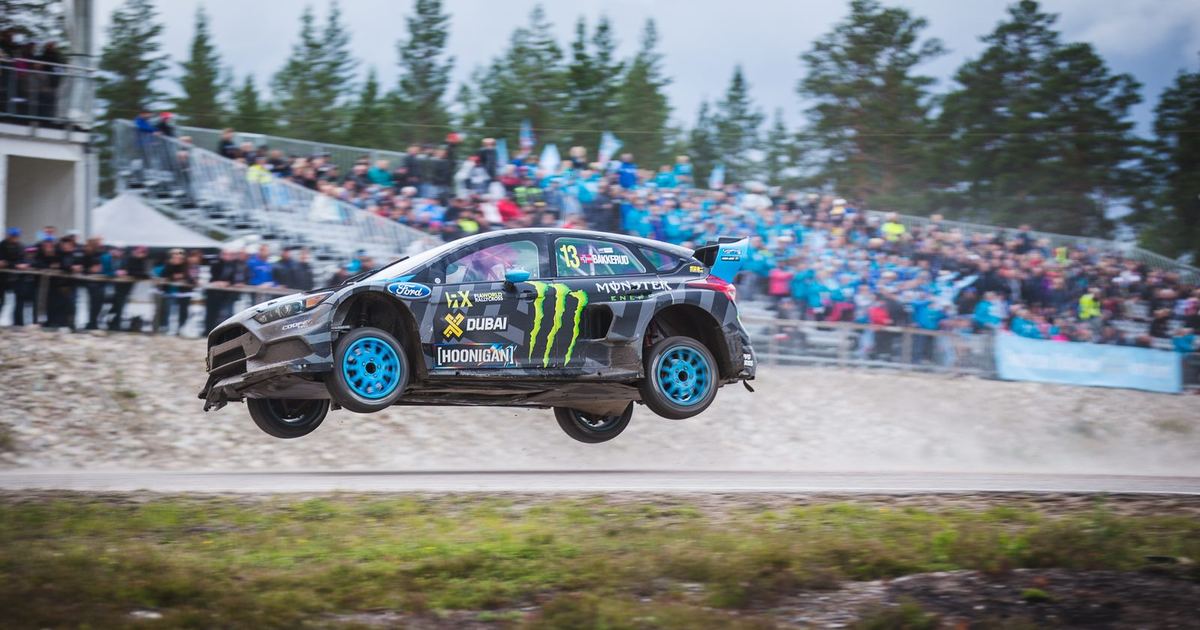a rallycross Supercar on a mixed-surface section, close enough to show detail on the car itself