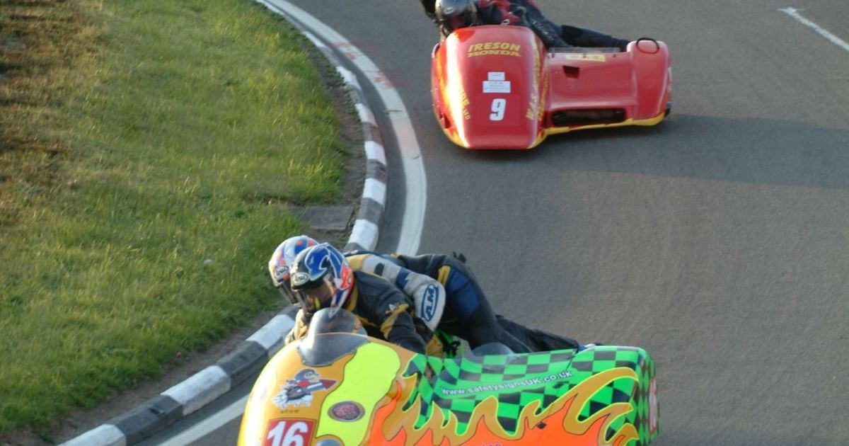 a road-racing sidecar outfit on a circuit, illustrating the discipline's history and distinct format