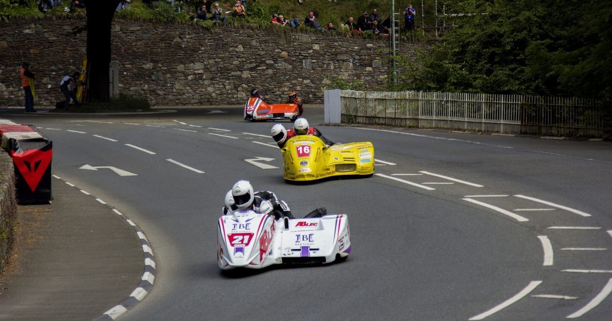 a sidecar passenger visibly working alongside the driver during a race, illustrating the two-person coordination