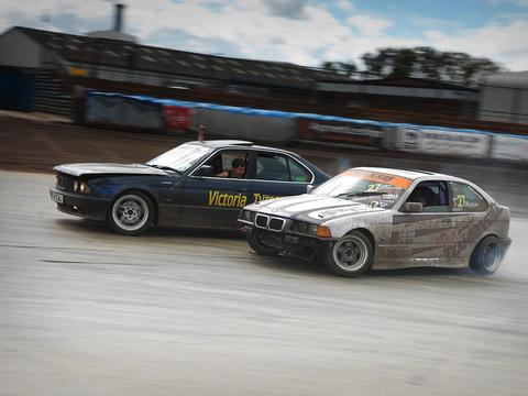 Two cars running a tandem drift battle