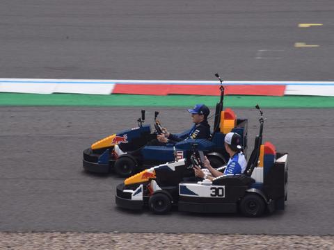 Isack Hadjar and Liam Lawson together at a promotional event during the 2026 British Grand Prix weekend