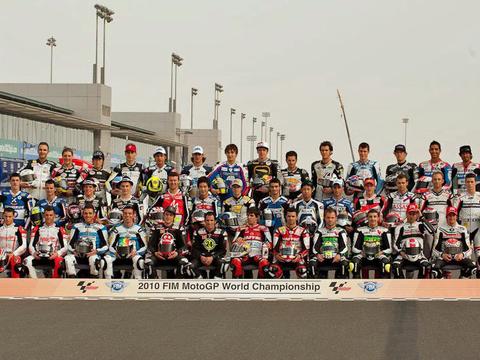 A pack of Moto2 riders racing closely together on the grid