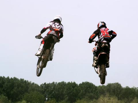motocross riders battling for position mid-moto, illustrating the two-moto format