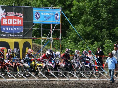 an outdoor motocross rider on natural terrain, representing either championship generically