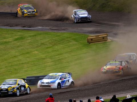 a rallycross car jumping on a mixed-surface circuit, contrasted conceptually against a WRC car on a rally stage