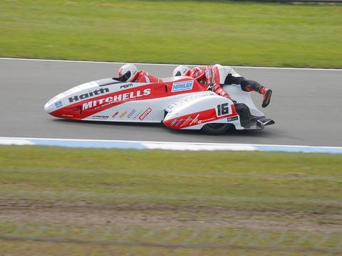 an experienced sidecar racing crew, driver and passenger together, illustrating the partnership newcomers would need to join