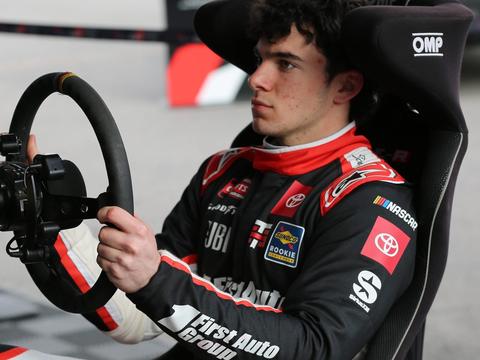 a sim racing rig positioned to visually suggest a comparison with real karting, such as a wheel and pedal setup