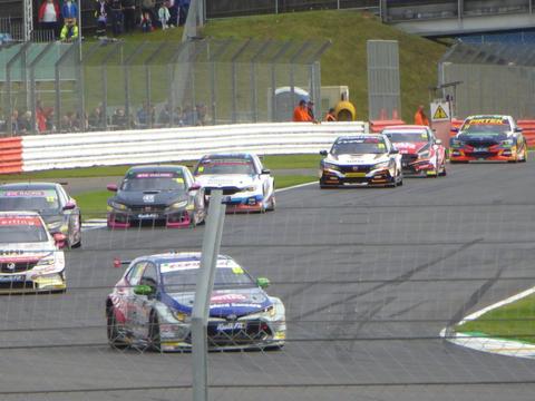 BTCC cars racing closely together, illustrating the tight midfield the equalizing system is designed to produce