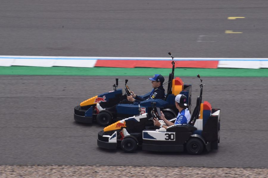 Isack Hadjar and Liam Lawson together at a promotional event during the 2026 British Grand Prix weekend