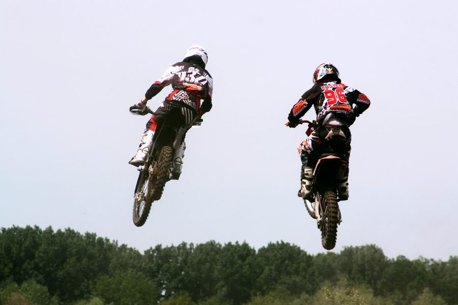 a supercross rider clearing a jump combination, illustrating rhythm-section riding