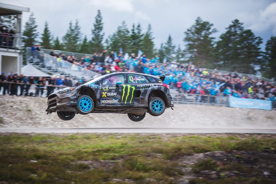 a rallycross Supercar on a mixed-surface section, close enough to show detail on the car itself