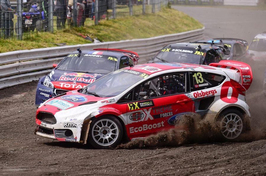 a rallycross car on a mixed tarmac-and-gravel circuit, illustrating the discipline's rally-derived origins