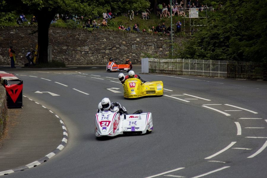 a sidecar passenger visibly working alongside the driver during a race, illustrating the two-person coordination