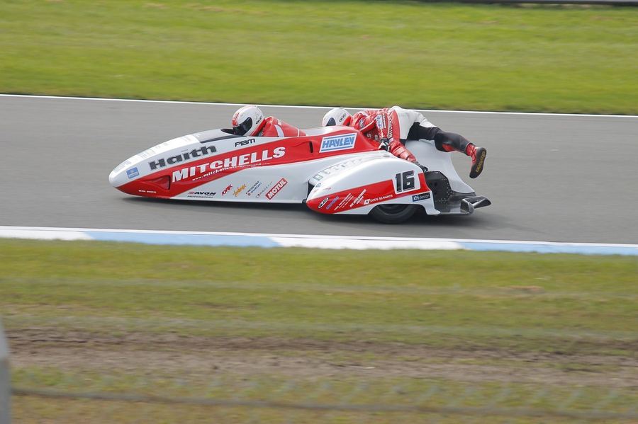 an experienced sidecar racing crew, driver and passenger together, illustrating the partnership newcomers would need to join