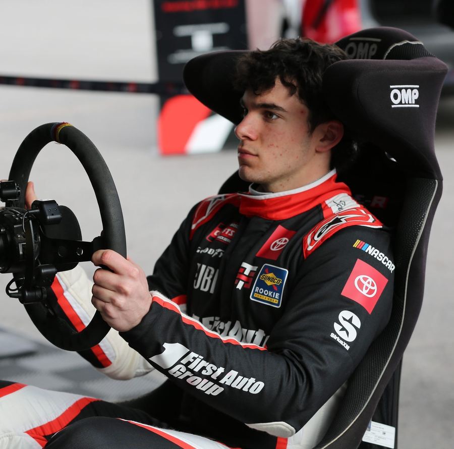 a sim racing rig positioned to visually suggest a comparison with real karting, such as a wheel and pedal setup